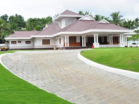 Happy carpenter sitting on the the roof beams and hammering a large nail