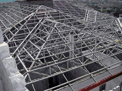 Roofer working on a new dormer by hammering nails into the roof edge
